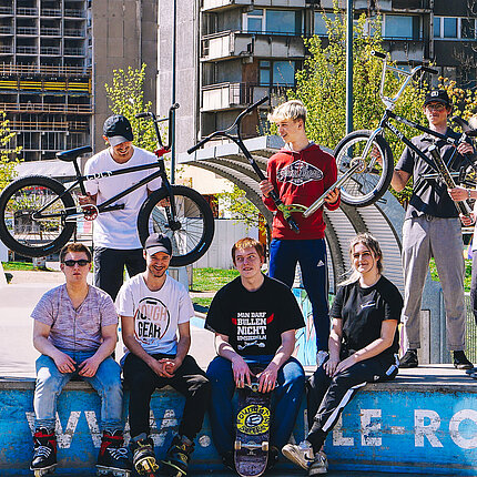 Eine Gruppe von Jugendlichen mit Fahrrädern auf einem Skateplatz
